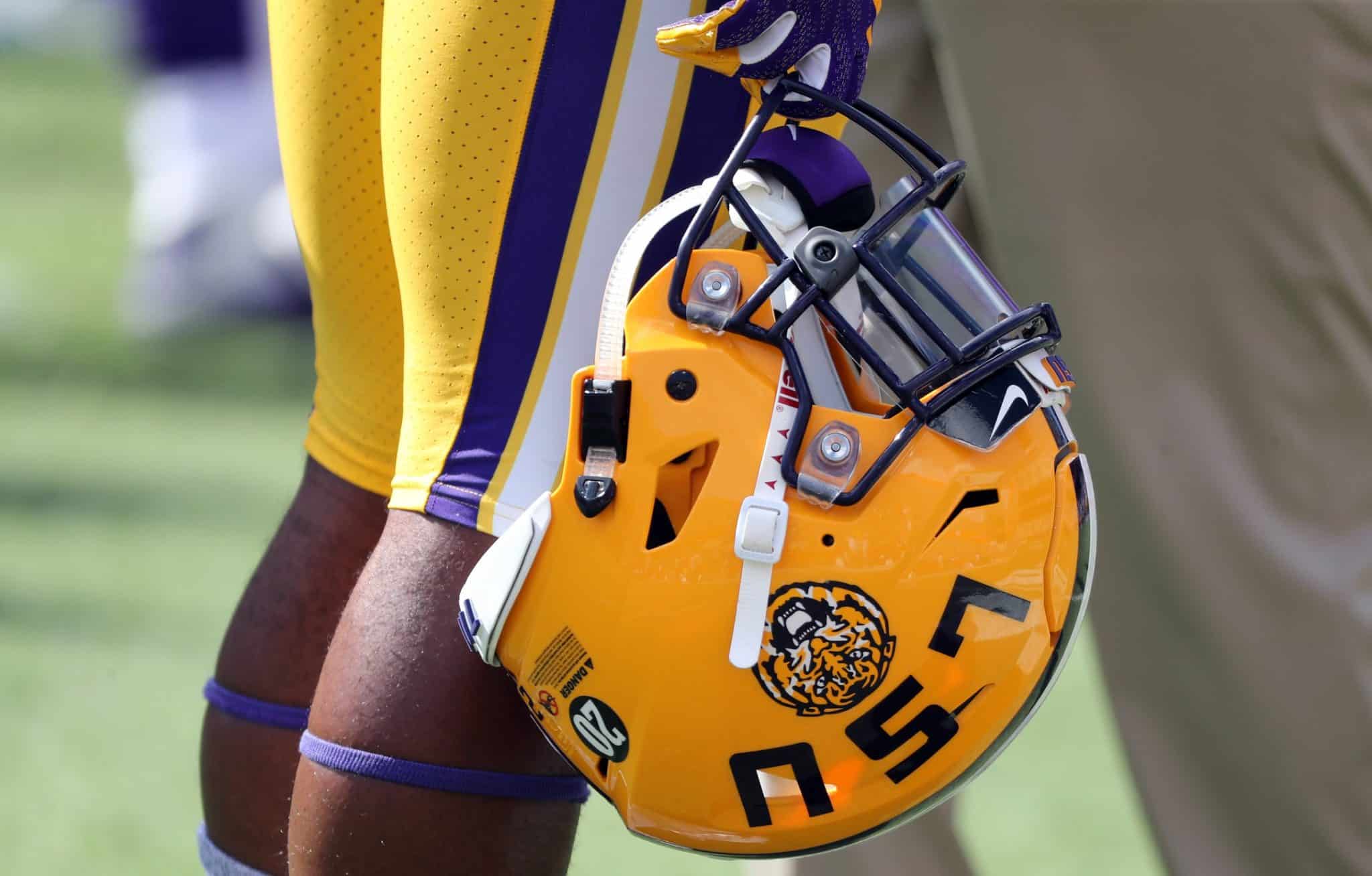 An LSU player holds his helmet.